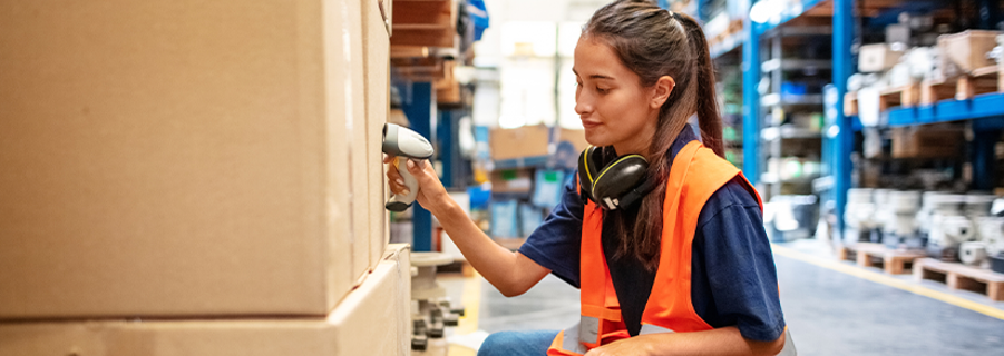 Ungarbejder er ved at scanne tung kasse på lager.